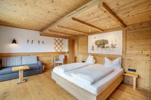 a bedroom with a large bed and a couch at Wein- und Klimahotel Bergfriedel in Bühlertal
