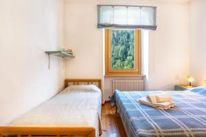 two beds in a room with a window at Casa Ai Laresi 1 in Peio