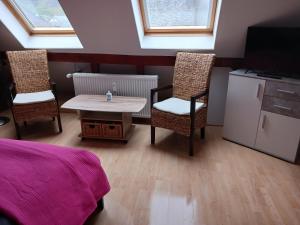 a bedroom with a table and two chairs and a tv at Ferienwohnung Gersch in Wolf