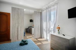 a living room with a bed and a large window at Cà du Mandaìn in Pairola
