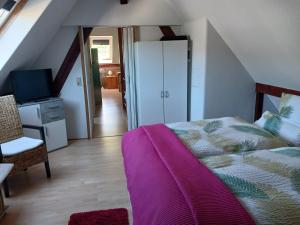 a bedroom with a bed with a purple blanket at Ferienwohnung Gersch in Wolf