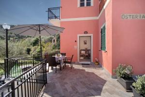 a patio with a table and an umbrella at Cà du Mandaìn in Pairola