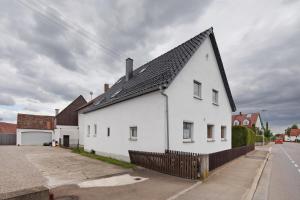 a white house with a black roof on a street at Haus Steinheim in Dillingen an der Donau