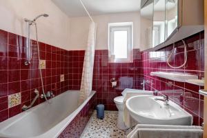a red tiled bathroom with a tub and a sink at Haus Steinheim in Dillingen an der Donau +21 photos
