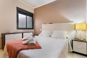 a bedroom with a large white bed with towels on it at Apartamento Romo in Candelaria