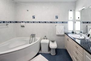 a bathroom with a tub and a toilet and a sink at Vivenda do Monte in Achadinha +29 photos
