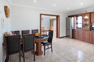 a kitchen and dining room with a table and chairs at Vivenda do Monte in Achadinha