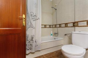 a bathroom with a toilet and a shower curtain at Apartamento Romo in Candelaria +19 photos