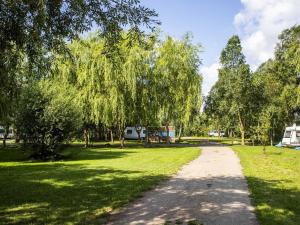 a dirt road in a park with trees at Peenecamp Neukalen, Campingplatz in Neukalen
