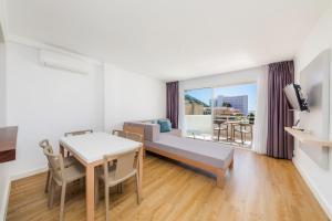 a living room with a couch and a table with a dining room at Apartament Massanet 2c in Canyamel