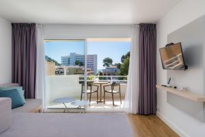 a living room with a view of a table and a balcony at Apartament Massanet 2c in Canyamel