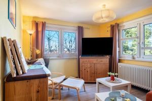 a living room with yellow walls and a flat screen tv at Blackforest Ferienwohnung in Sankt Georgen im Schwarzwald