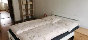 a bed with white sheets and flowers on it at Ferienwohnung Mücheln 2 in Mücheln