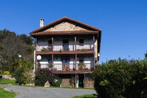 a large house with a balcony on the side of it at Fuenternilla in Carranza