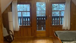 a bedroom with three windows and a bed in a room at Ferienhaus in Finsterbergen in Friedrichroda