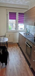 a kitchen with wooden cabinets and a table and windows at Ferienwohnung Mücheln 2 in Mücheln