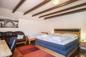 a bedroom with a large bed and a couch at Ferienhaus Villa Kanisblick in Bizau