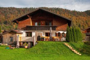 a house on a hill with a grass yard at Ferienhaus Villa Kanisblick in Bizau