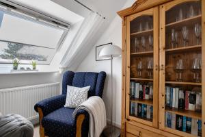 a room with a blue chair and a book shelf at Ferienwohnung Marita Carstensen in Viöl