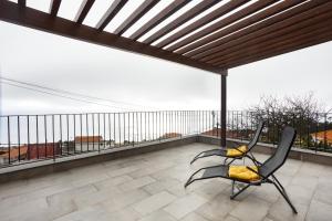 a chair on a balcony with a roof at Referta Apartamento T1 in Prazeres