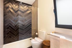 a bathroom with a toilet and a shower at Referta Apartamento T1 in Prazeres +13 photos