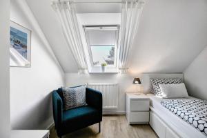 a small bedroom with a bed and a chair at Ferienwohnung Marita Carstensen in Viöl