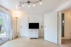 a living room with a television on a white dresser at Ferienwohnung Haus Oehlberg in Todtmoos