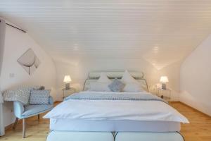 a bedroom with a white bed and a blue chair at Ferienwohnung Haus Oehlberg in Todtmoos