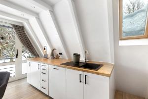 a kitchen with white cabinets and a sink and a window at Nurdachhaus Sauerland in Kirchhundem