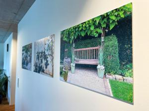 a row of pictures on a wall with a bench at Ferienwohnung Grüner Ausblick in Elzach