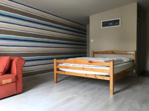 a bedroom with a wooden bed and a striped wall at Hâvre de Paix Perros in Perros-Guirec