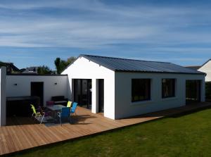 a house with a deck with a table and chairs at Hâvre de Paix Perros in Perros-Guirec