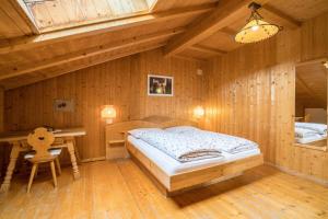 a bedroom with a bed and a desk in a room at Ferienwohnung Aster Nusserhof in Avelengo