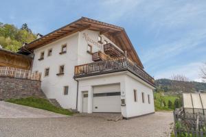 a white building with a balcony on top of it at Ferienwohnung Aster Nusserhof in Avelengo