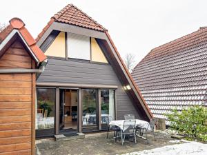 a house with a patio with a table and chairs at Gemütliches Nurdachhaus Bodensee in Immenstaad am Bodensee
