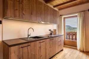 a kitchen with a sink and a large window at Ferienwohnung Aster Nusserhof in Avelengo +13 photos