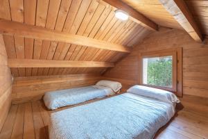 a room with two beds in a wooden cabin at Falaguera Barraca 3 in Bárig +18 photos