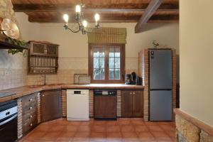 a large kitchen with wooden cabinets and a refrigerator at Villa los mellizos in Arriate