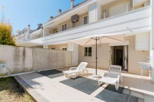 a patio with two chairs and an umbrella at Casa vacanze Elettra in centro in Otranto