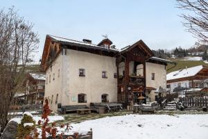 a large building in the winter with snow on the ground at Plazores in San Vigilio Di Marebbe