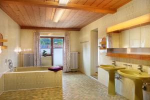 a bathroom with a tub and two sinks and a bath tub at Ferienunterkünfe Beim Posthalter in Oberammergau +58 photos