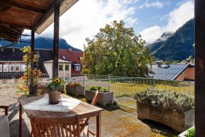 a patio with a table and some plants and a fence at Ferienunterkünfe Beim Posthalter in Oberammergau