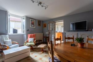 a living room with a table and a tv at Chambre d'hôtes Ticounat in Piets-Plasence-Moustrou