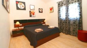 a bedroom with a bed with a black comforter at Can Olivaret in Campos