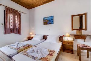 two beds in a room with a mirror at Studio Rea in Póndi