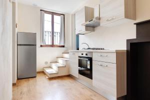 a kitchen with white walls and wooden floors and a staircase at Casabianca - The best for bikers in Finale Ligure