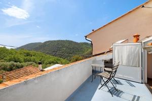 a balcony with two chairs on the roof of a house at Casabianca - The best for bikers in Finale Ligure
