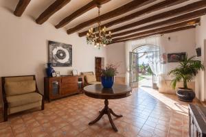 a living room with a table and a chair at Masía Can Trabal in Olerdola