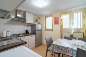 a kitchen with a table with chairs and a refrigerator at Il cappello sulle 23 in Avola