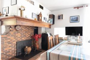 a living room with a fireplace and a dining table at Gite Bellevue Accous in Accous